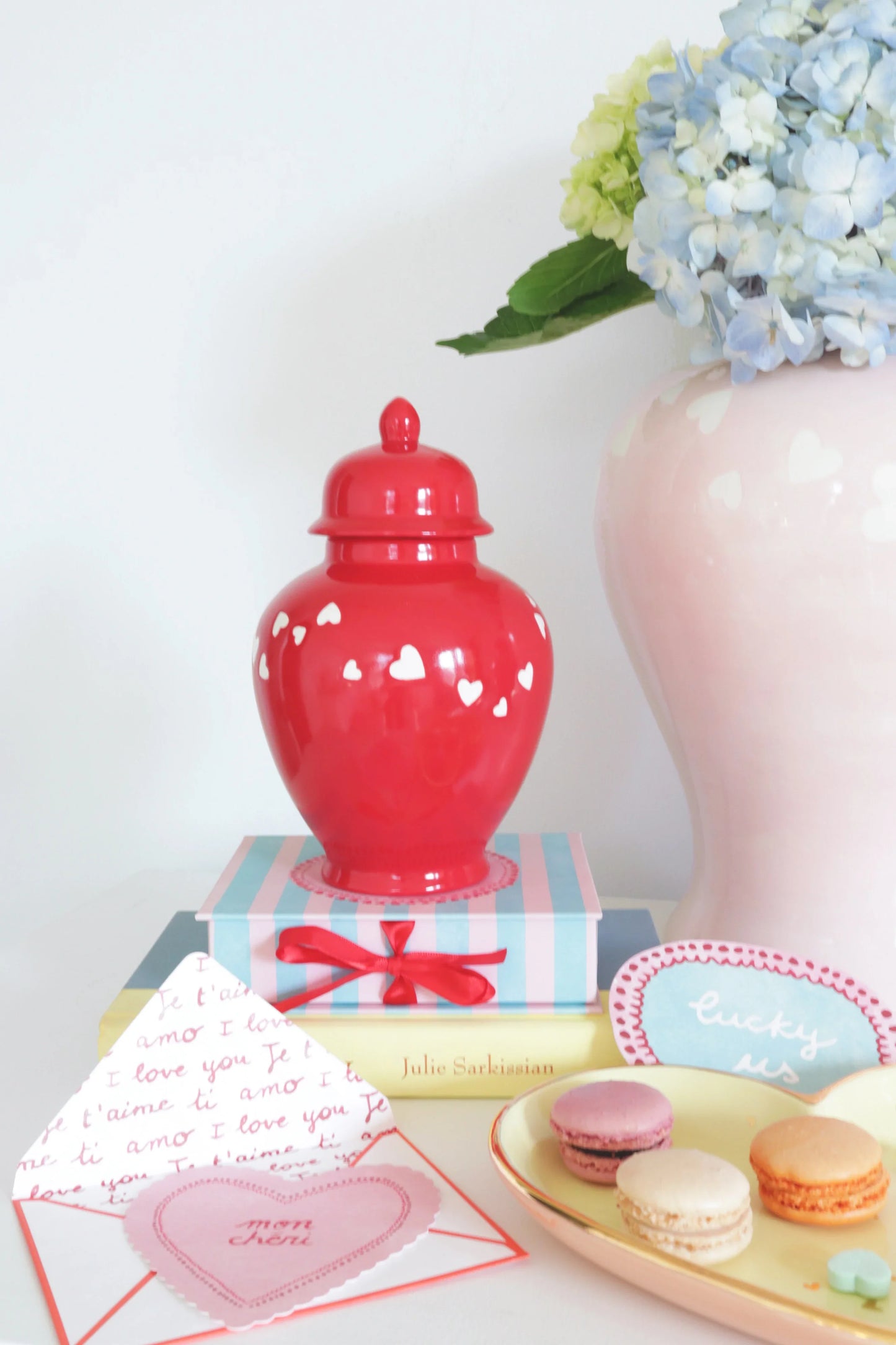 Elegant 'Love is in the Air' ginger jar in red displayed in a cozy home décor setting.