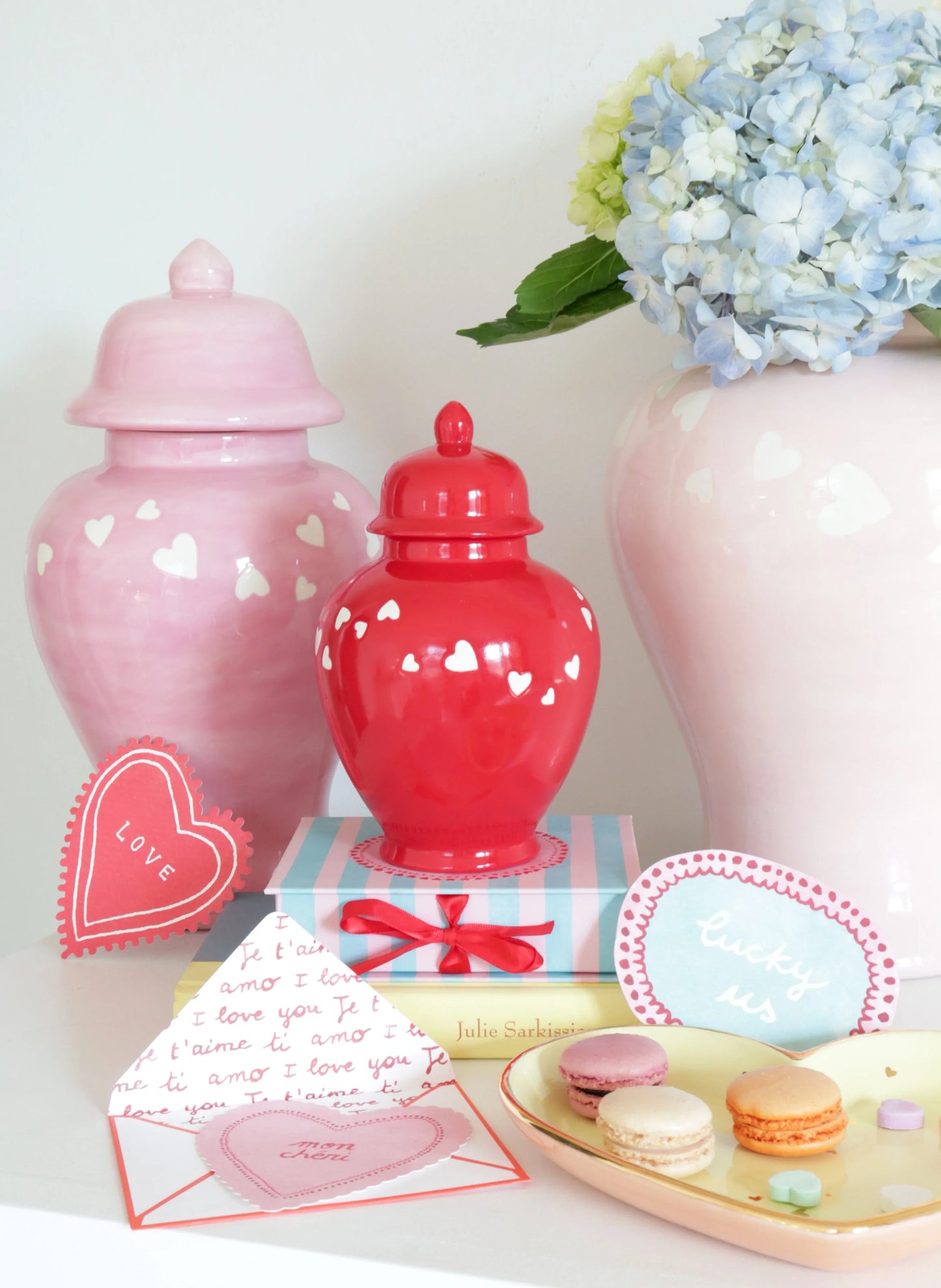 Stacked 'Love is in the Air' red ginger jars, perfect for stylish storage.