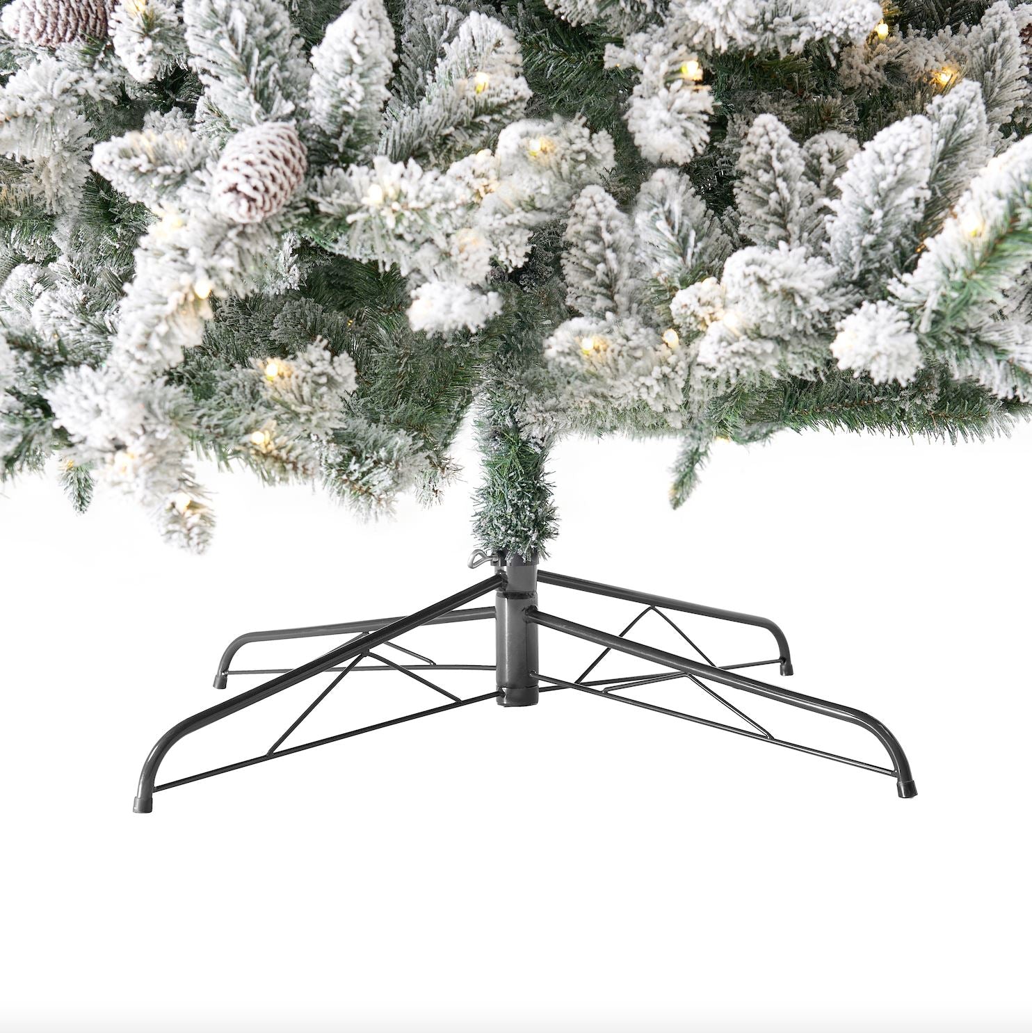 The 10’ Flocked Livingston Fir Artificial Christmas Tree with a sturdy metal stand, ready for holiday celebrations.